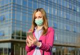 Woman in facemask looks at mobile