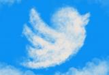 The Twitter logo formed by clouds against a bright, blue sky