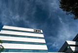 An IBM building in front of a backdrop of dark blue, cloudy skies