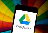 Google Drive being accessed on a smartphone in front of a multi-coloured umbrella